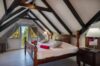 Attic bedroom with exposed beams and garden view at Villa Plumbago, Colombier, St Barts luxury rentals.