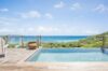 Terrace with shaded pergola, infinity pool, and sweeping ocean views at a St Barts villa rental
