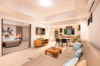 Open-plan living area in a St Barts villa with modern kitchen, dining table, and lounge leading to a bedroom.
