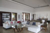 Spacious living room with white sofas, glass coffee table, and built-in bookshelves at a luxury St Barts villa