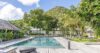 Spacious swimming pool surrounded by palm trees and sun loungers at a luxury St Barts villa rental