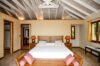 Primary bedroom in St Barthelemy vacation rentals with wooden furniture and vaulted ceiling