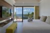 Modern bedroom in a St Barts villa with balcony access, ocean views, and minimalist décor in soft neutral tones.