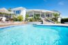 Sparkling turquoise pool framed by sun terrace and elegant villa in St Barts luxury rental.