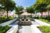 a beautifully landscaped tropical garden with a stone fountain in the center, leading to the villa's entrance.