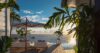 Sunset terrace with lounge chairs and ocean views framed by tropical plants at St Barts villa rental.