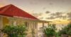 St Barts villa with red roof terrace overlooking ocean at golden sunset