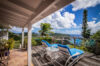 Sun terrace at St Barts villa with loungers overlooking Caribbean hills and ocean
