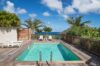 Private pool at St Barts villa with sun loungers, palm trees, and ocean views