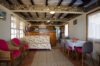 Cozy villa living and dining area with rustic wooden beams, wicker chairs, and bright accents in St Barts villa rental