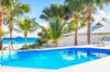 Beachfront St Barts villa with private pool surrounded by palm trees, just steps from the Caribbean Sea.