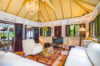 Tropical-style living room with high ceiling, white sofas, and wooden shutters in St Barts villa