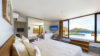 Bedroom in St Barts villa with floor-to-ceiling windows, private pool access, and ocean view.