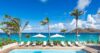 Beachfront pool with sun loungers and umbrellas overlooking the turquoise sea in St Barts villa rental