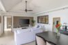 Modern villa living room with white sofas, flat screen TV, and tropical accents in St Barts vacation rental.