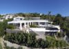 Modern St Barts villa with poolside deck, sleek white lounge seating, and shaded outdoor dining area beside the infinity pool.