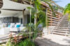 Shaded patio with white lounge chairs and tropical plants at St Barts vacation rental