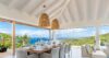 Open-air dining room with ocean views and rattan pendant lights at St Barts villa rental