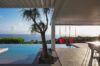 Covered terrace with pool, ocean view, and red swing chairs at St Barth villa rental
