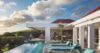 Covered terrace with pool, ocean view, and red swing chairs at St Barth villa rental
