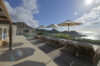 Spacious villa terrace with sun loungers, umbrellas, and panoramic ocean views in St Barts luxury vacation rental