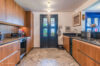 Stylish kitchen in a St Barts villa with wooden cabinetry, patterned tile floor, and modern appliances under warm lighting