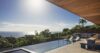 Modern pool terrace at a St Barts villa with sun loungers, shaded lounge seating, and panoramic ocean views at sunset.