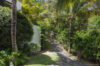 Tropical garden pathway at a St Barts villa shaded by palm trees and lush greenery, creating a serene island escape.