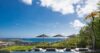 Poolside terrace at a St Barts villa with sun loungers, black umbrellas, and panoramic views of the Caribbean Sea and hillsides.