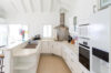 Bright kitchen with white cabinets, modern appliances, and breakfast bar at St Barts vacation rental