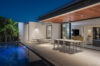 Evening terrace with dining table, lounge chairs, and poolside view at luxury villa in St Barts