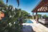 Peaceful sunbathing spot next to a calm pool, featuring comfortable loungers and stunning views of the surrounding scenery.