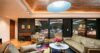 Lounge room with large windows offering a beautiful view of the outdoors.