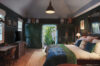 Inviting bedroom with dark green walls, writing desk and garden access in St Barts vacation rental