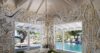 Modern lounge room with large windows offering a beautiful view of the natural landscape outside.