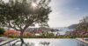 Beautiful scene featuring an infinity pool seamlessly blending into the natural surroundings, with lush greenery and scenic views all around.
