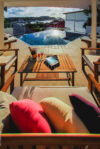 Sunset view from St Barts villa terrace with infinity pool, champagne, and colorful cushions, luxury villa rental