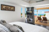 “Bright bedroom at St Barts villa with ocean-view terrace, lounge chairs, and modern design, vacation rental St Barths
