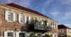 Historic stone building with red roof and shuttered windows in Gustavia, St Barts