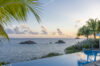 Peaceful poolside retreat with crystal-clear water and an unobstructed view of the ocean waves.