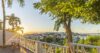 Scenic villa terrace with wooden railing, palm trees, and sunset view over Gustavia harbor in St Barts vacation rental