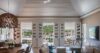 Bright living room with vaulted ceiling and French doors opening to marina view in St Barts villa rental.