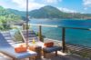 Sun deck at St Barts villa with loungers and ocean views of lush hills