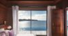 Seafront bedroom in a St Barts villa with wooden walls and sliding doors opening to ocean views