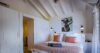 Cozy bedroom in St Barts villa with vaulted ceiling, soft lighting, and modern artwork