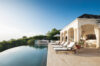 Comfortable sun loungers shaded by umbrellas, perfect for lounging in the sun.