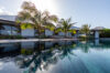 Sparkling pool beside swaying palms, enhancing the charm of a luxury villa
