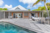 Wooden deck with pool, dining set, and lounge chairs at private villa rental in St Barts