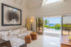 Sunlit living room with white sofa and sliding doors to pool at St Barts villa rental
