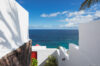 Whitewashed villa passage in St Barts opening to panoramic Caribbean Sea views